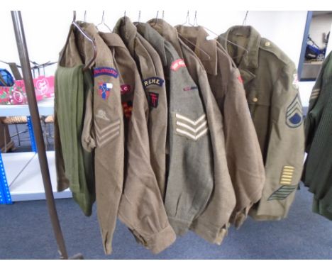 Seven 20th century British army tunics bearing badges together with three pairs of trousers (11)