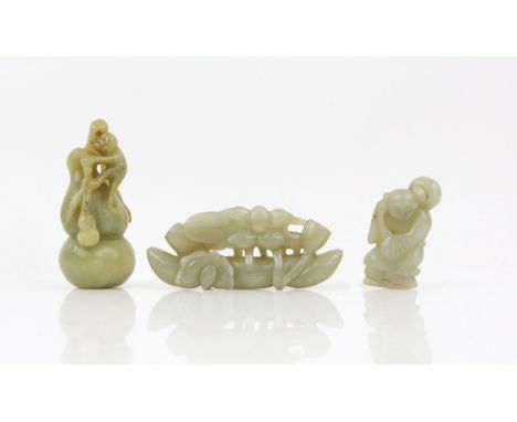 Three Chinese carved jades, comprising one as a bird and lotus, 10cm long, a figure carrying a peach, 6cm high, a monkey on a
