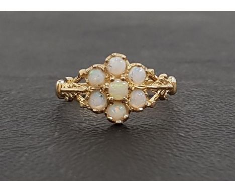 OPAL CLUSTER RINGthe seven round cabochon opals flanked by shaped and pierced shoulders, on nine carat gold shank, ring size 