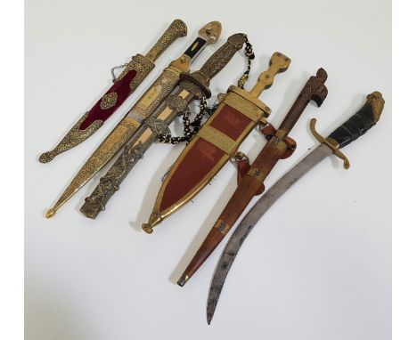 SELECTION OF SIX DECORATIVE DAGGERSincluding an Indian example with a 23cm long blade with a carved teak and brass inlaid han