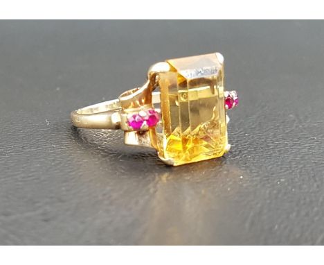 CITRINE AND RUBY DRESS RINGthe large central emerald cut citrine measuring 13.5mm x 10mm x 6.35mm, flanked by two rubies to e