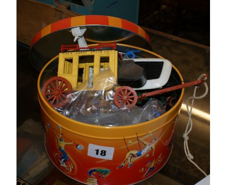 Circular tin containing plastic figures of cowboys and Indians with stagecoach and kayak by Timpo toys.