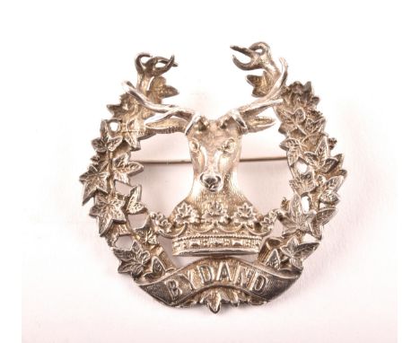 A Scottish Gordon Highlanders badge, modelled in relief with the stag and ducal coronet within ivy wreath and banner embossed