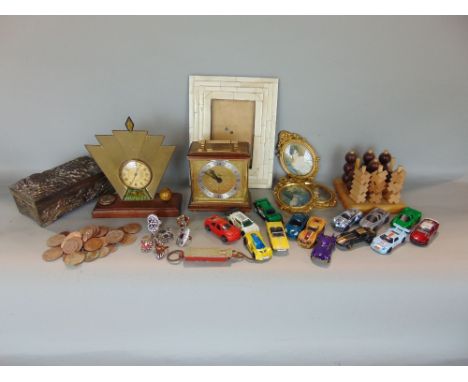 A collection of miscellaneous items to include an Art Deco clock, a piano key ivory frame, various die-cast toys, coins, etc