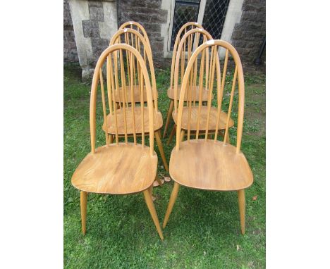 A set of six Ercol blonde elm and beechwood high hoop and stick back dining chairs raised on splayed supports united by high 