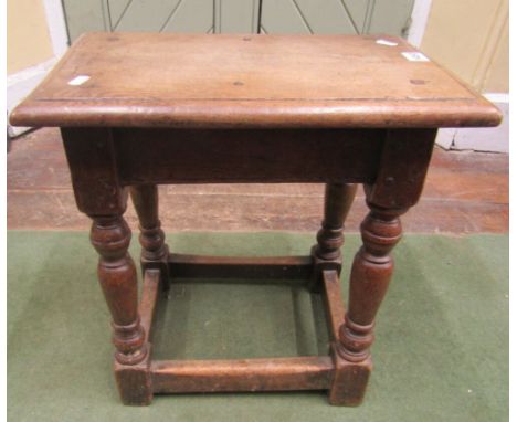 An Old English oak joint stool with pegged frame on turned supports