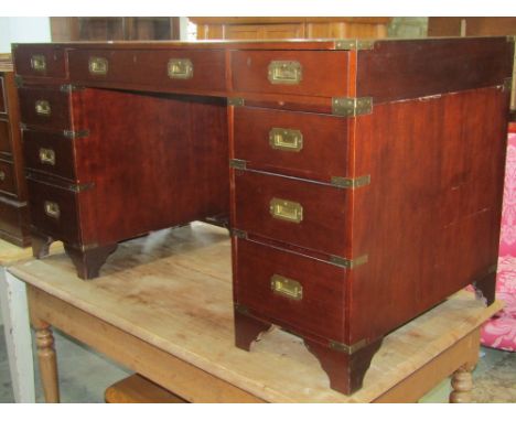 A reproduction mahogany kneehole twin pedestal writing desk in the military/campaign style with inset leather panel top over 