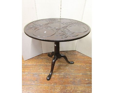 A 19th century mahogany supper table, the circular top for five plates, within a carved floral trail, raised on a gun barrel 