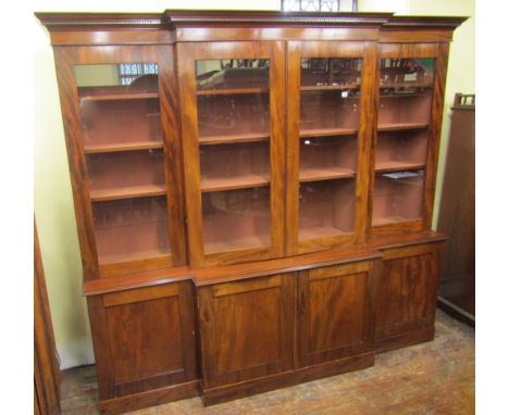 A good quality mahogany breakfront four door bookcase, the lower section enclosed by panelled doors, the upper section by gla