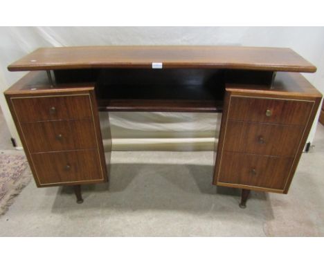 A retro Herbert Gibbs walnut veneered twin pedestal dressing table of curved and canted form, each pedestal fitted with three