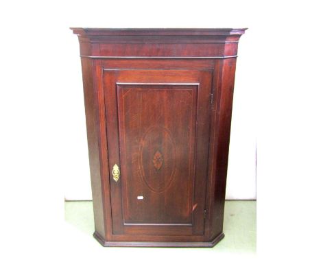 A Georgian oak and inlaid crossbanded hanging corner cupboard enclosed by a single door, with central conch shell, the later 