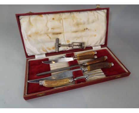 A cased set five piece horn handled carving set together with a corkscrew