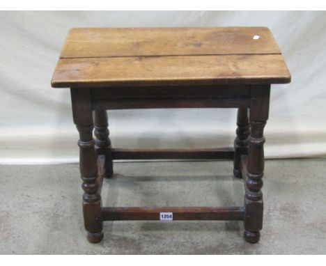 A small Old English style oak occasional table or stool of rectangular form with moulded rails and turned supports and three 