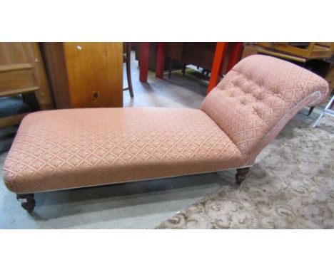 A Victorian chaise/day bed with floral lattice patterned upholstered seat and rolled button back raised on turned supports wi