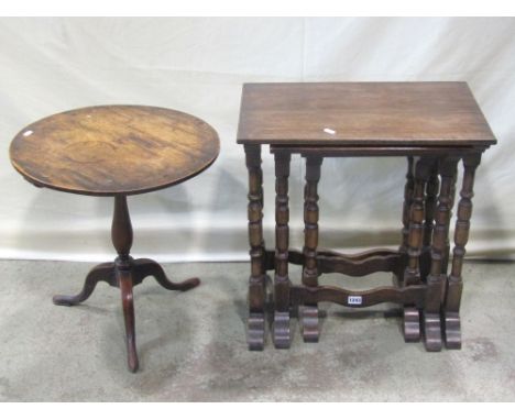 A nest of three good quality reproduction Old English style oak occasional tables, raised on turned column supports, united b