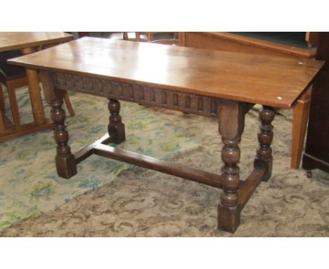 A good quality Old English style oak refectory table, the over hanging rectangular top raised on four turned legs with carved