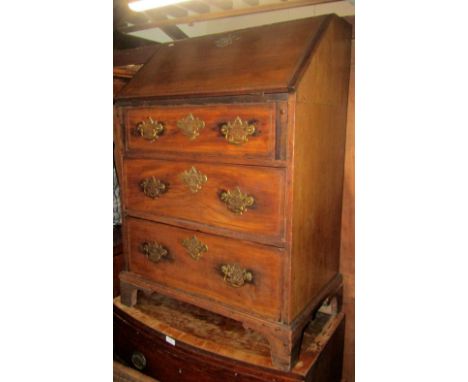A small Georgian mahogany writing bureau, the fall flap enclosing a simple pigeon holed interior, over three long graduated d