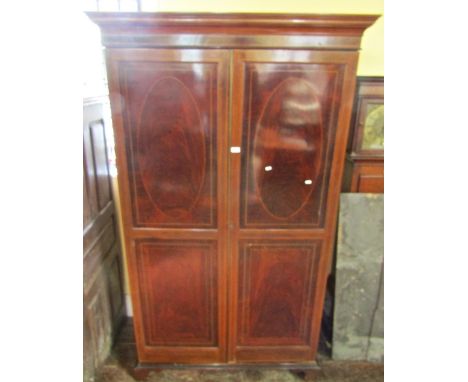 A good quality Edwardian hanging cupboard in the Sheraton manner, the doors enclosed with inlaid panels and raised on bracket