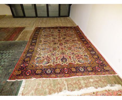 Traditional Old Persian carpet, oatmeal ground central panel with all over stylised floral pattern with a blue multi pattern 