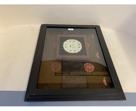 Jade pierced disk 11/5cm diam in a large glazed frame 