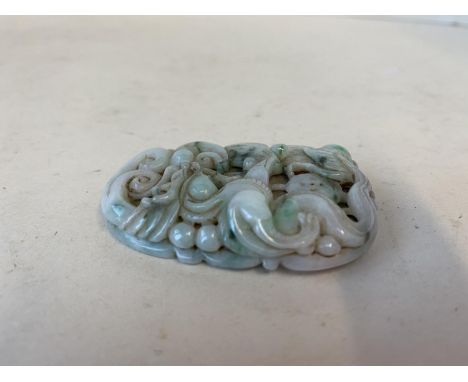 A very finely carved jade pendant with mythical dragons and sea serpents, 6cmL 