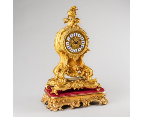 A FRENCH ORMOLU MANTEL CLOCKIn the Louis XV style, circa 1860The case of shaped outline with foliate scroll cresting, the 5 1
