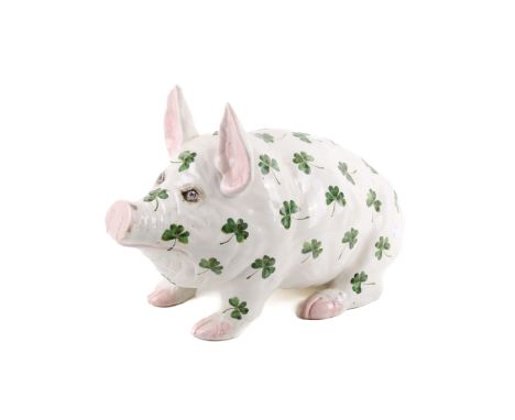 A Wemyss Ware pottery pig. Circa 1900, modelled in a seated position, glazed in white with hand painted clover leaf decoratio