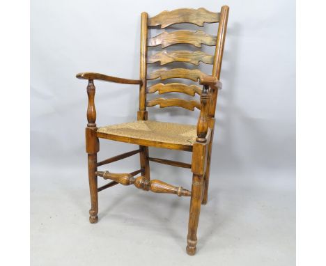 A Lancashire style oak ladder-back rush-seated elbow chair 