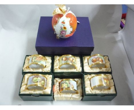 A BOXED ROYAL WORCESTER 'PEACH' CANDLE SNUFFER, and six English Enamel napkin rings (7)