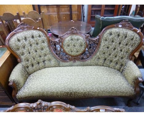 A VICTORIAN STYLE SOFA, with carved frame and olive patterned upholstery