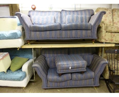 AN UPHOLSTERED THREE PIECE SUITE, comprising a three seater settee, a two seater settee and a pouffe