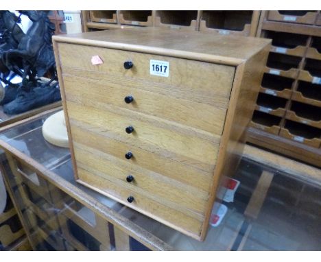 A SMALL LIGHT OAK COUNTER TOP CHEST, of six drawers