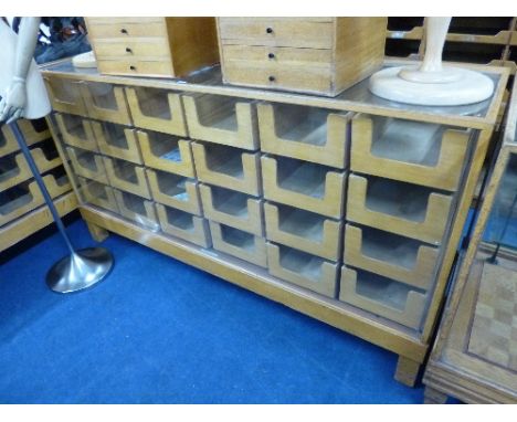A LIGHT OAK GLAZED SHOP DISPLAY COUNTER, with 24 drawers, Clements Newling and Co Ltd, Middlesex label attached