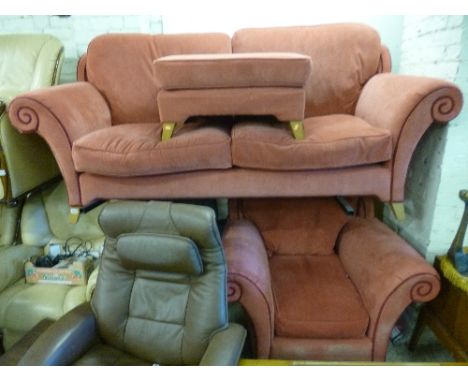 AN UPHOLSTERED THREE PIECE SUITE, comprising a three seater settee, an armchair and a pouffe