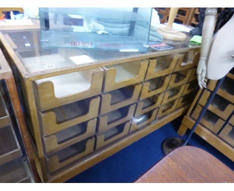 A LIGHT OAK GLAZED SHOP DISPLAY COUNTER, with 24 drawers, Clements Newling and Co Middlesex label attached