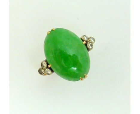 A JADE AND DIAMOND RING, the oval shaped cabachon jade flanked by a triangle of single cut diamond detail, marks rubbed, ring