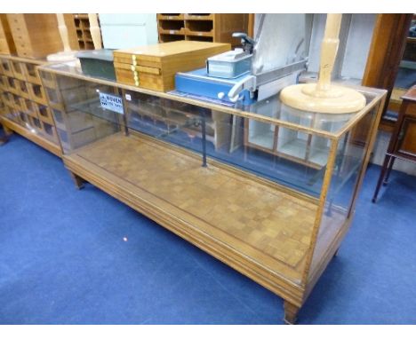 A LIGHT OAK GLAZED SHOP DISPLAY COUNTER, with shelf