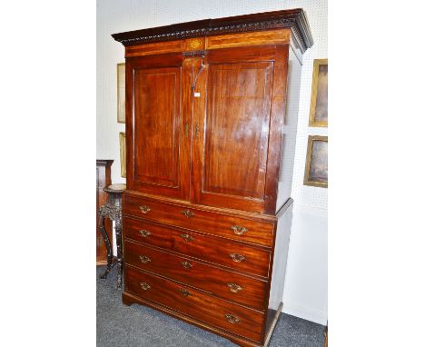 An unusual early George III mahogany linen press, the breakcentre gadrooned and dentil stepped cornice above a deep frieze, c