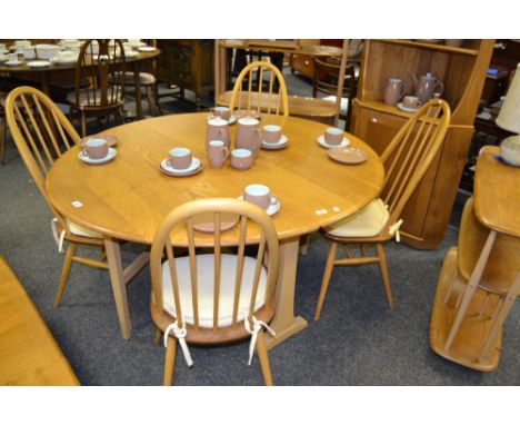 An Ercol retro elm drop leaf table and four spindle back chairs, c.1960