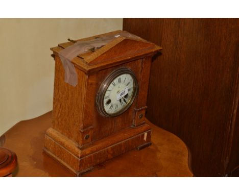 A late Victorian oak mantel clock, the 11cm diam white enamel dial painted with Roman and Arabic numerals, 14 day movement st