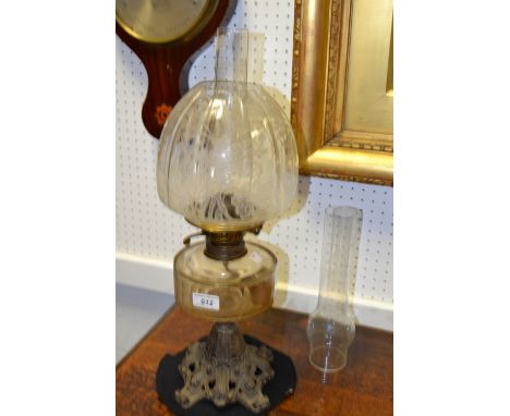 An Art Nouveau cast iron and clear glass oil lamp, printed shade, clear reservoir, ornate cast base