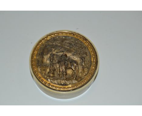 A George III circular silver gilt mounted ivory table snuff box, the cover embossed with a cavalier taking ale by the tavern,