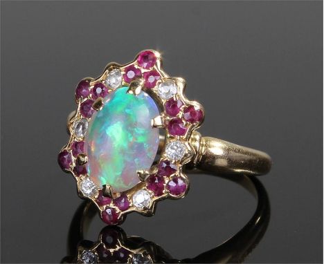 Yellow metal opal, ruby and diamond set ring, the central opal surrounded with rubies and diamonds, ring size N