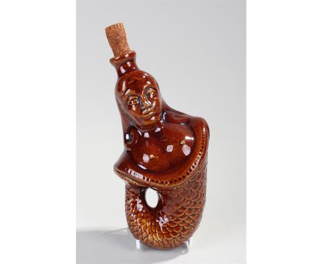 19th Century treacle glazed mermaid spirit flask, the figural bottle with cork stopper, curled tail, 20cm high