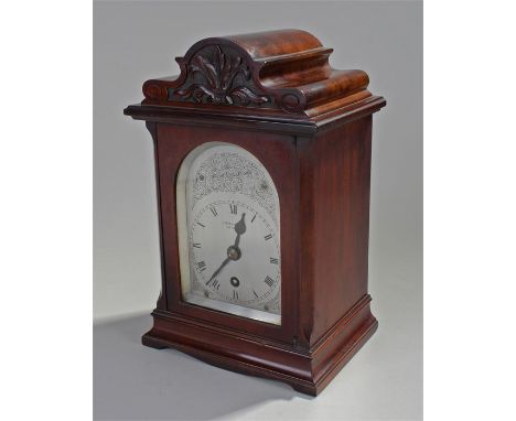 George III style mahogany bracket clock, J.W. Benson, the arched top with carved leaf decoration, above an arched glass door,