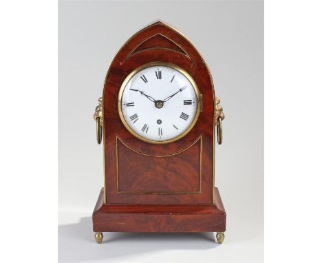 Regency mahogany lancet clock, the case with brass bound edges, lion mask handles, raised on acorn feet, the white enamel dia