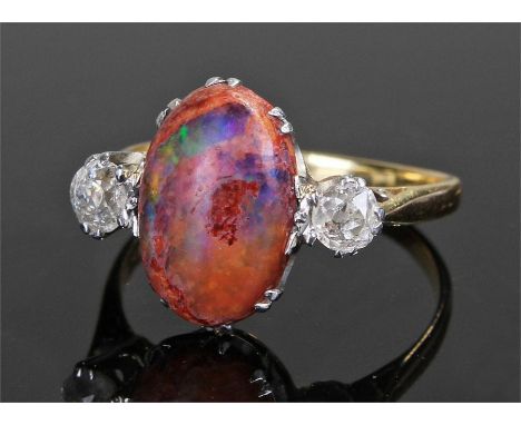 Yellow metal fire opal and diamond set ring,the oval fire opal flanked by a diamond to each side, ring size S