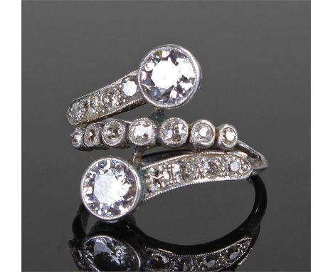 Art Deco white metal and diamond set ring, with three bands of seventeen diamonds, the two largest at the end of the bands be