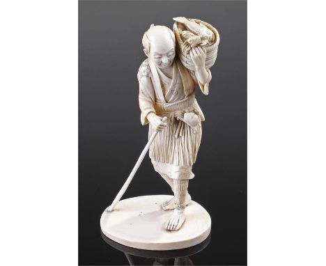 Large Japanese Meiji period ivory okimono, modelled as a fisherman, with a basket of fish with a crab to his hand, clutching 