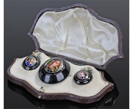 Enamel jet and silver jewellery, the cased three piece with enamelled brooch of a lady with engraved silver border, jet mount